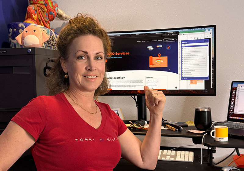Adrienne Folse owner of Design the Planet digital marketing in front of computer with website SEO on the screen